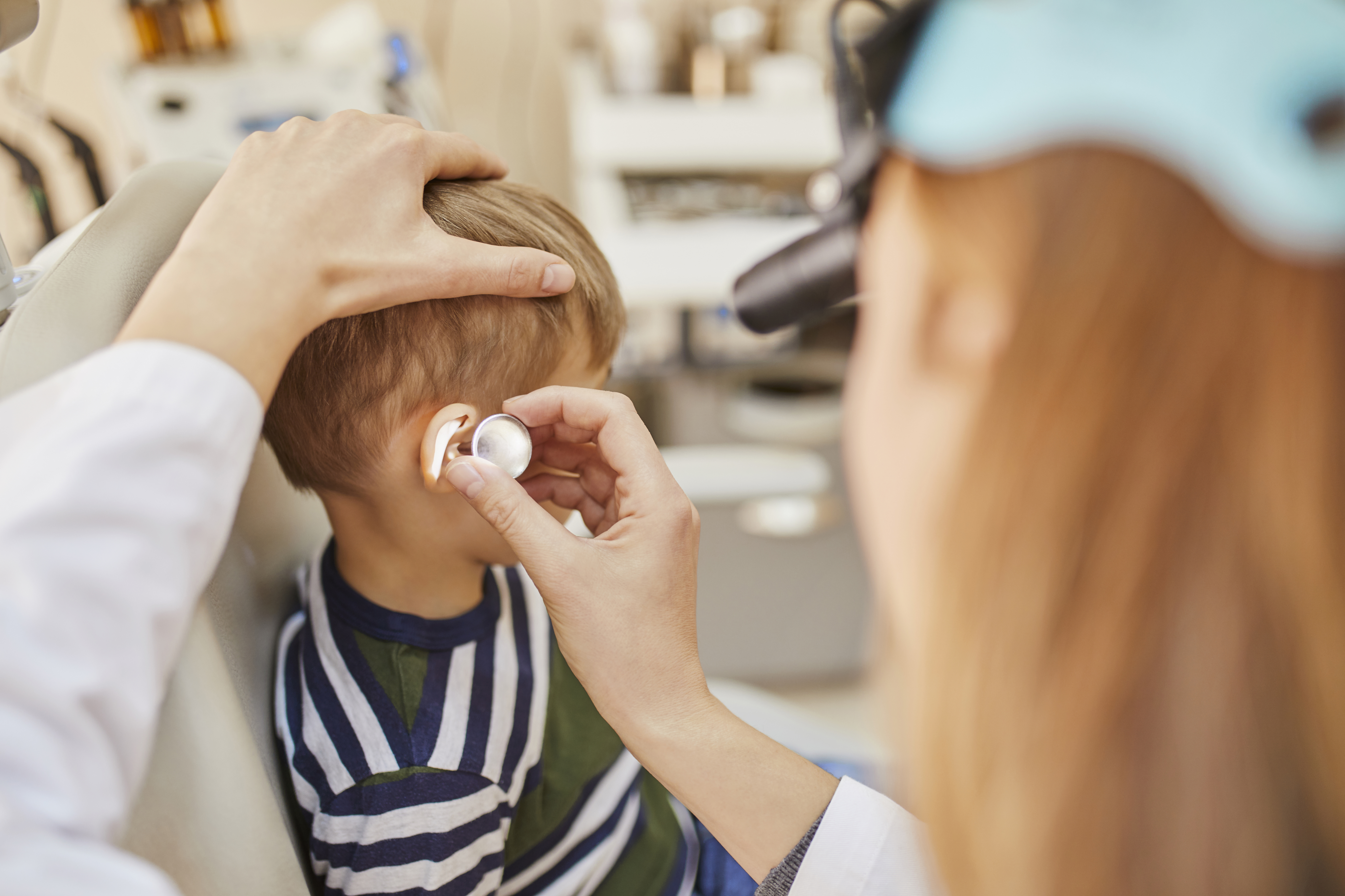 ENT physician examining ear of a boy